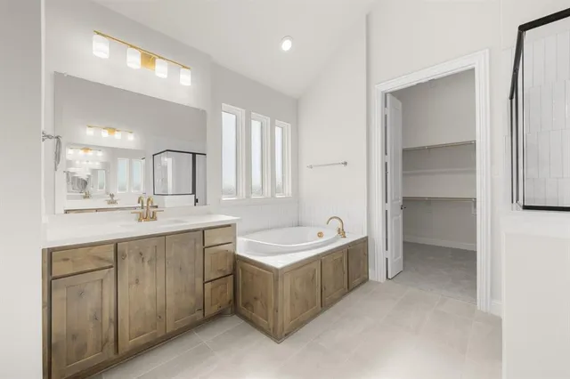 a bathroom with a sink double vanity granite tub shower and a mirror
