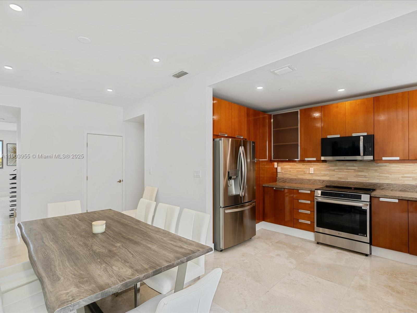 155 North Shore Drive, Unit 1553 Miami Beach, FL 33141 - Photo 11 of 48 a kitchen with stainless steel appliances granite countertop a refrigerator a stove and a sink