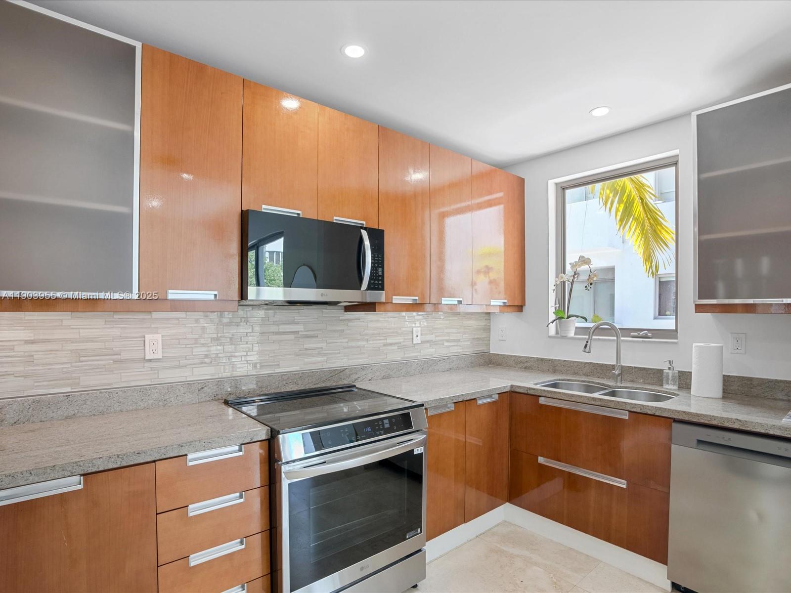 155 North Shore Drive, Unit 1553 Miami Beach, FL 33141 - Photo 14 of 48 a kitchen with stainless steel appliances a sink stove and microwave
