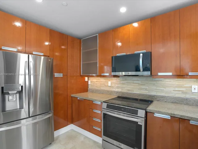 a view of a kitchen with a sink and stainless steel appliances