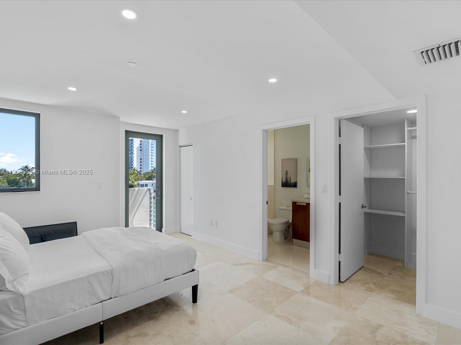 155 North Shore Drive, Unit 1553 Miami Beach, FL 33141 - Photo 21 of 48 a spacious bedroom with a bed and a couch