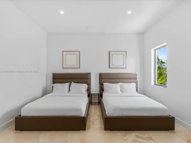 a bedroom with two beds and painting on the wall