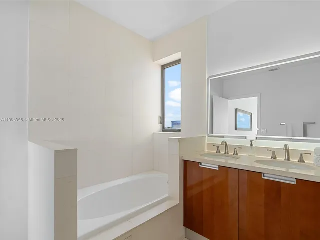 a bathroom with a tub sink and mirror