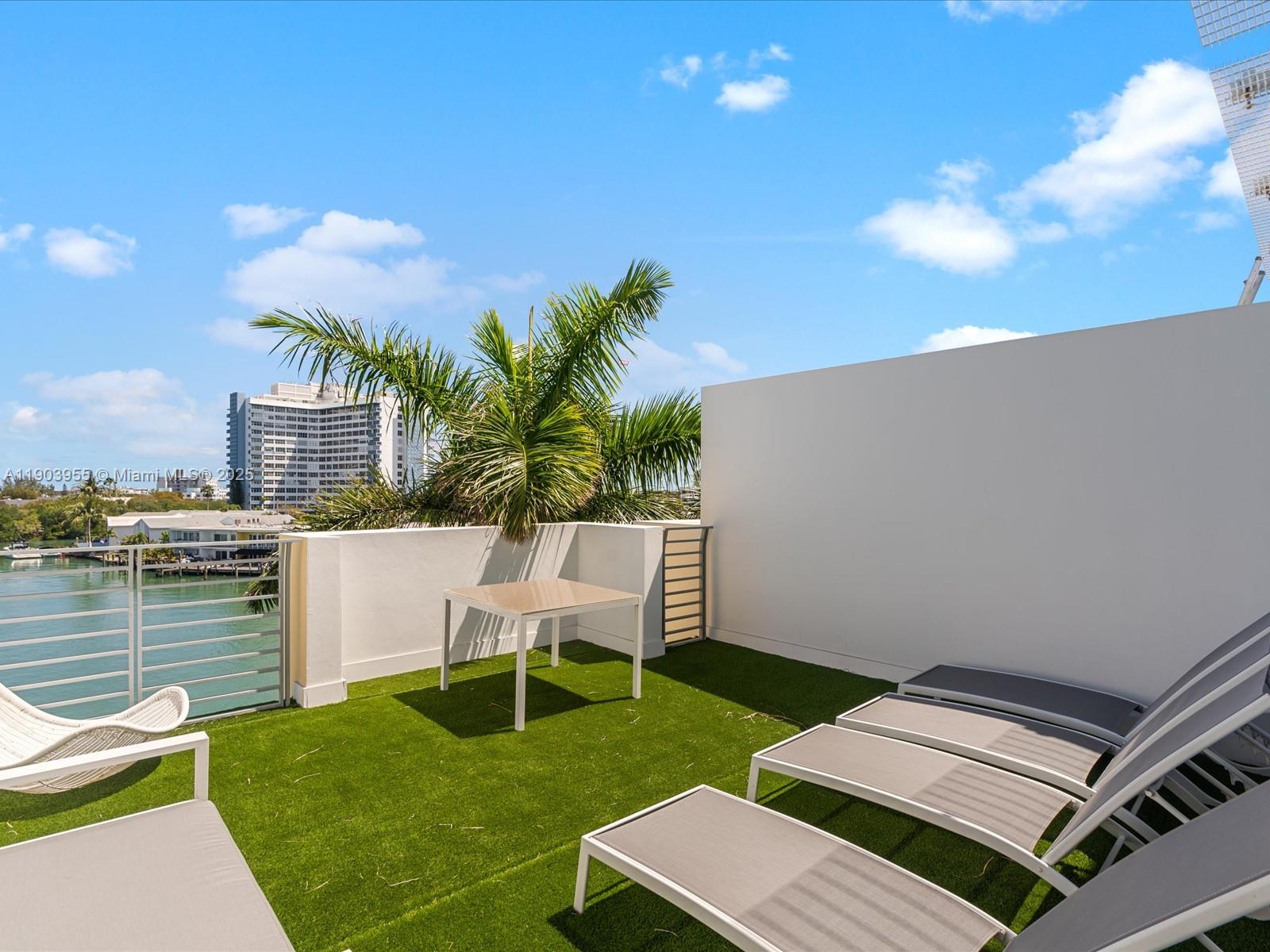 155 North Shore Drive, Unit 1553 Miami Beach, FL 33141 - Photo 40 of 48 a view of a patio with table and chairs with wooden floor and fence