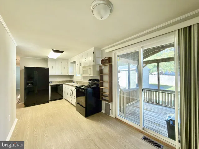 a large kitchen with kitchen island granite countertop a large window and stainless steel appliances