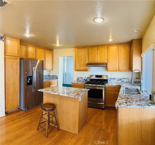 a kitchen with stainless steel appliances granite countertop a stove refrigerator sink and cabinets