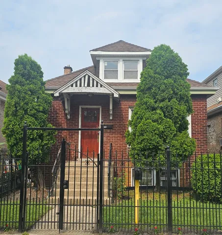 a front view of a house with a tree
