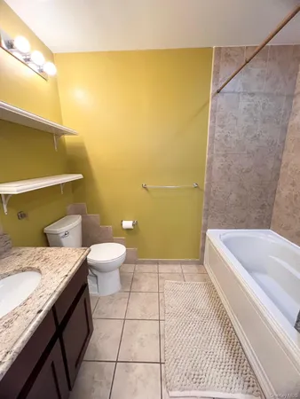 a bathroom with a granite countertop sink toilet and bathtub