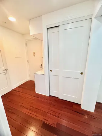 an empty room with wooden floor and entrance