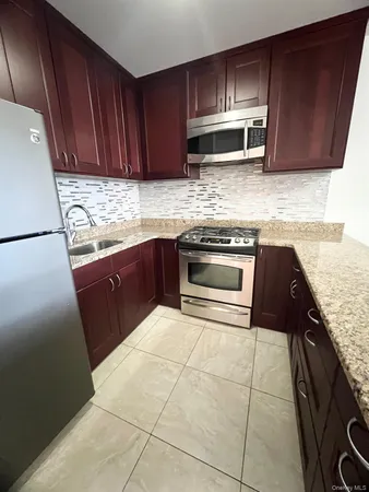 a kitchen with granite countertop wooden cabinets and stainless steel appliances