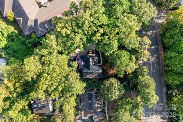 aerial view of a house with a yard and large trees