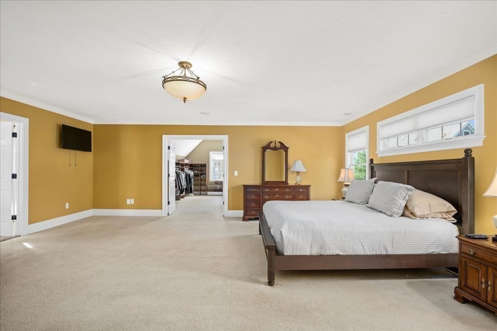 9 Laurel Ridge Lane Shrewsbury, MA 01545 - Photo 21 of 41 a bedroom with a bed and a chandelier