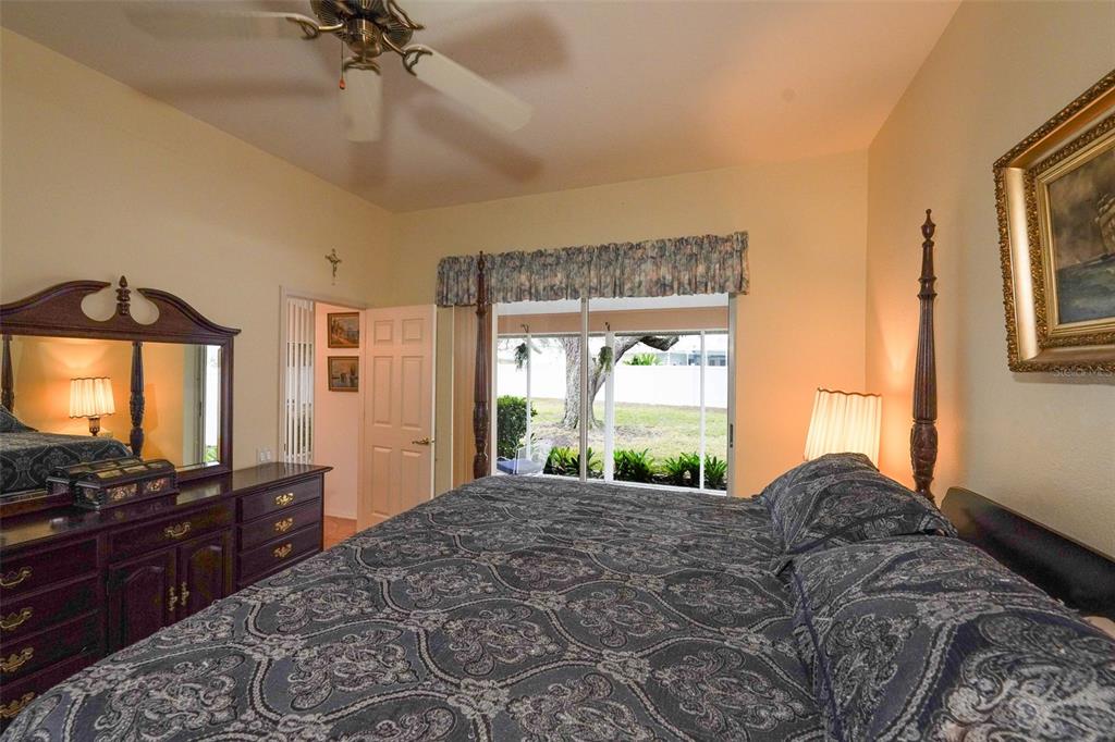 7340 Flyway Drive Spring Hill, FL 34607 - Photo 15 of 32 a bedroom with a bed and a flat tv screen on dresser