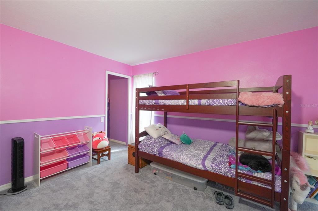 7340 Flyway Drive Spring Hill, FL 34607 - Photo 21 of 32 a bed room with a bed and a chair