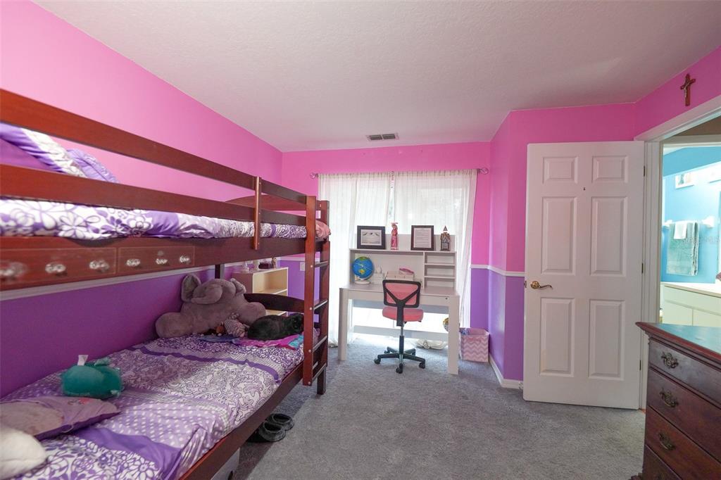 7340 Flyway Drive Spring Hill, FL 34607 - Photo 22 of 32 a bed room with a bed and a chair