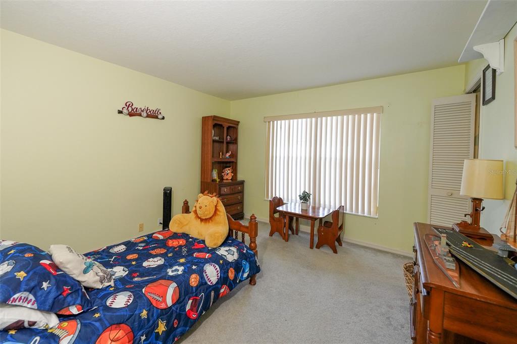 7340 Flyway Drive Spring Hill, FL 34607 - Photo 25 of 32 a bedroom with a bed and a couch