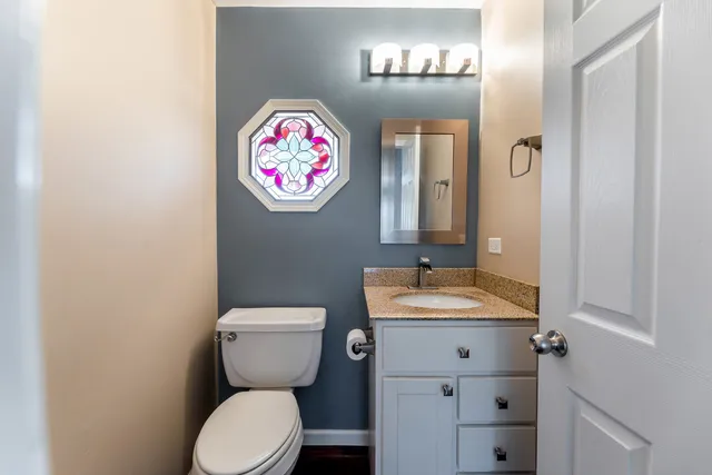 a bathroom with a toilet a sink and a mirror