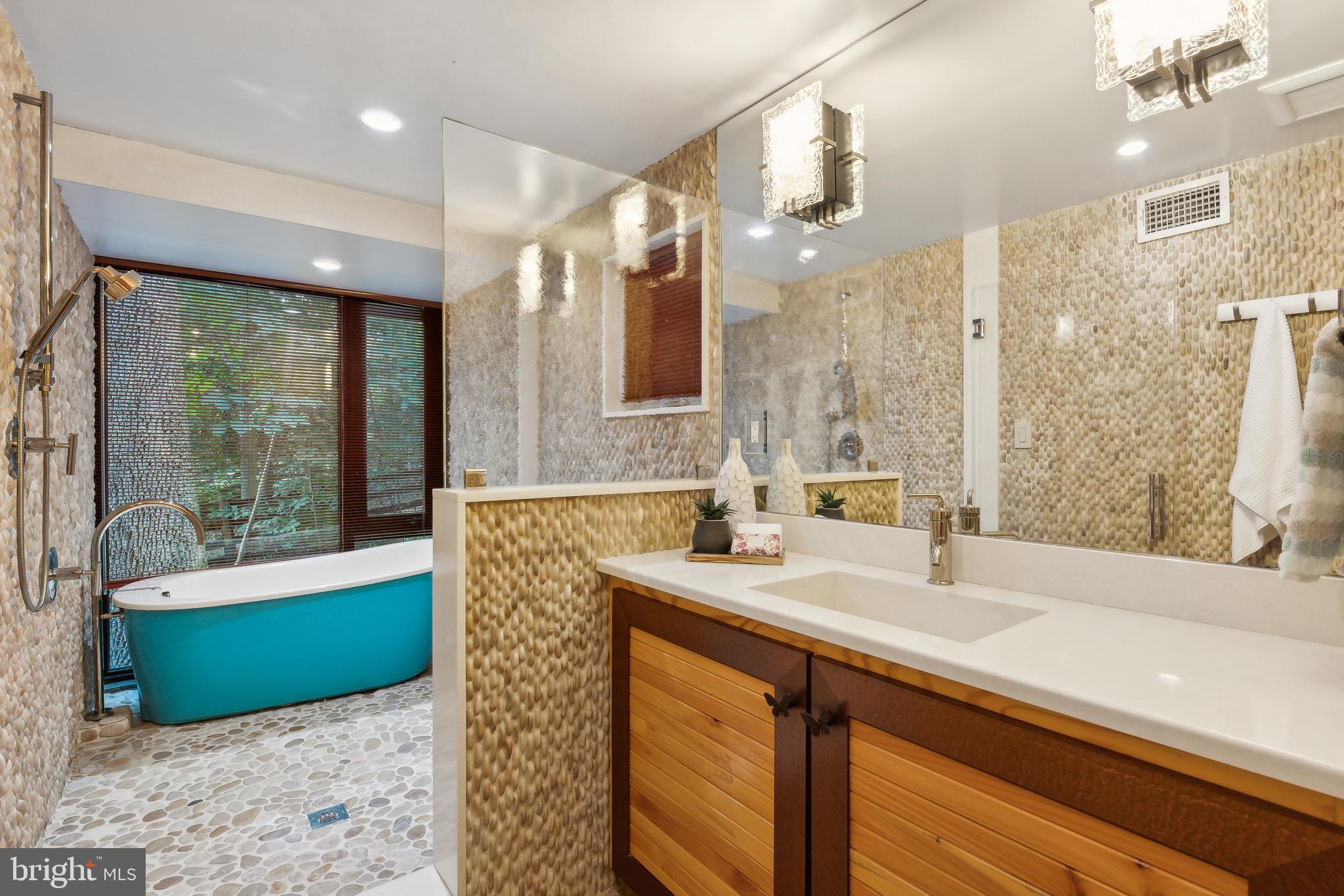 11540 Springridge Road Potomac, MD 20854 - Photo 22 of 35 a bathroom with a granite countertop sink a large mirror and a bathtub
