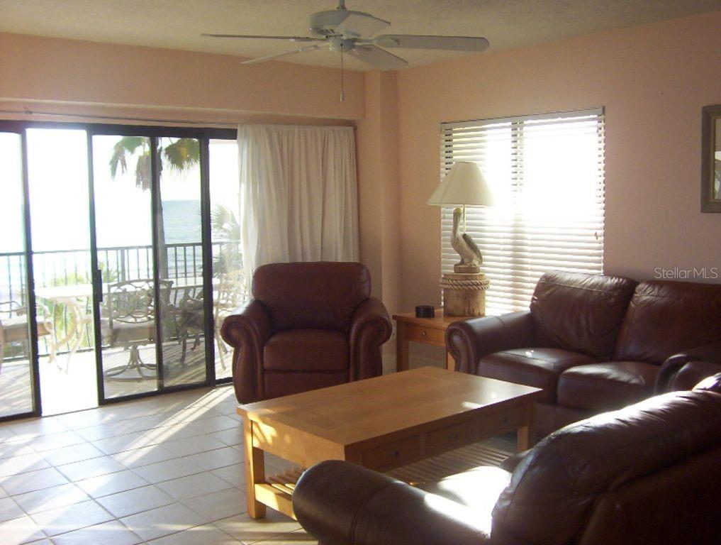 13650 Gulf Boulevard, Unit 304 Madeira Beach, FL 33708 - Photo 19 of 63 a living room with furniture and a floor to ceiling window