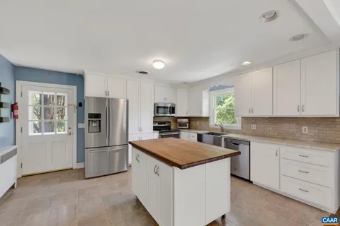 a kitchen with white cabinets and stainless steel appliances