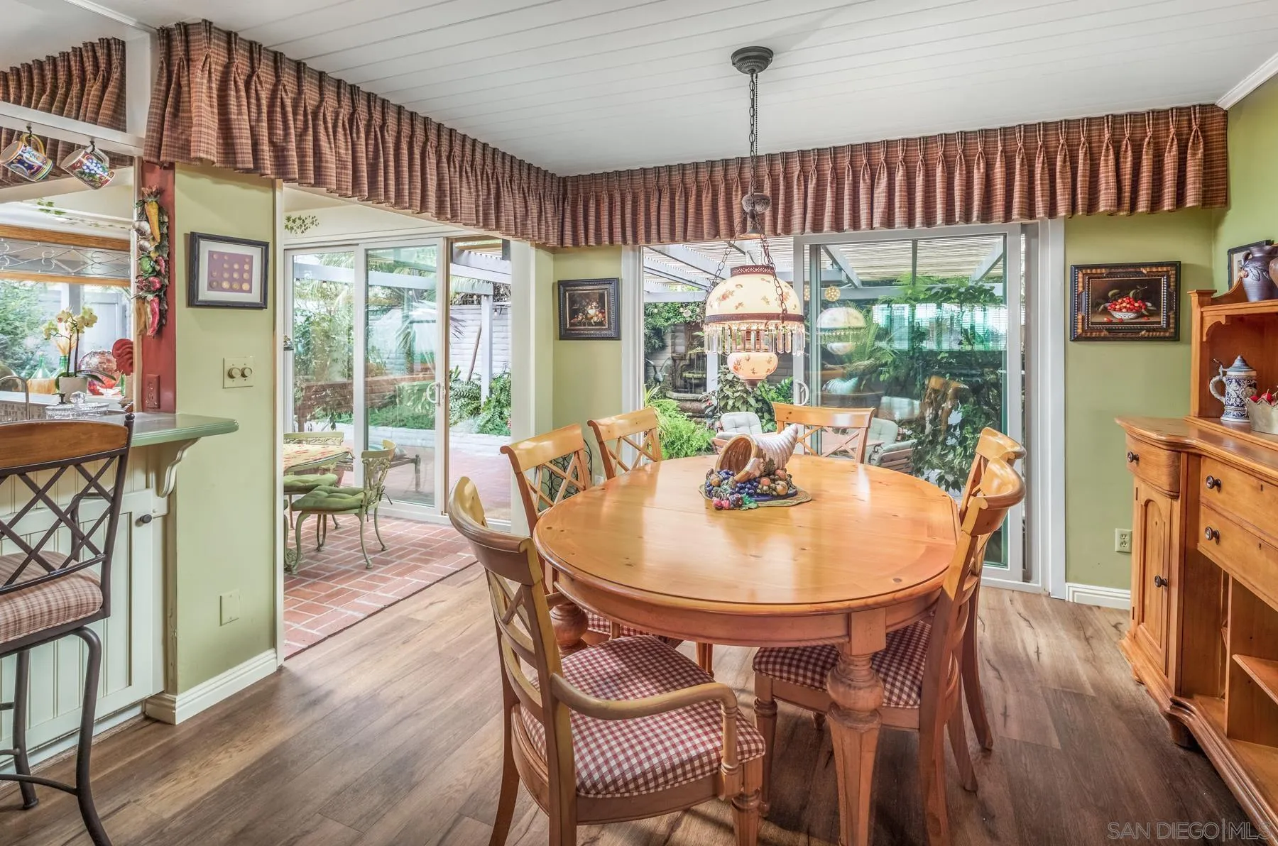 5118 Shore Drive Carlsbad, CA 92008 - Photo 13 of 21 a dining room with furniture a chandelier and wooden floor