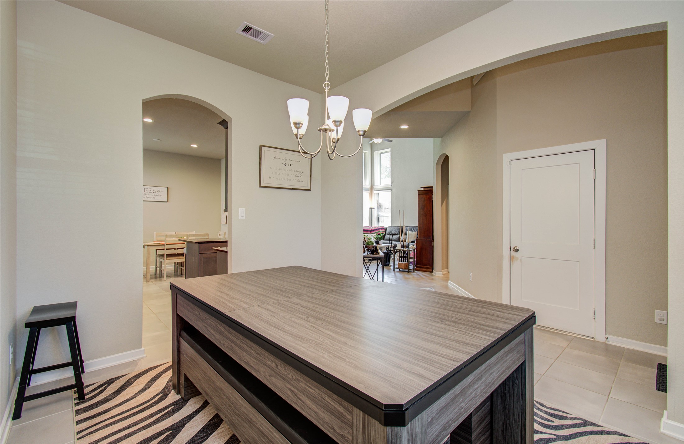 22290 Rustling Cone Court Porter, TX 77365 - Photo 4 of 30 a dining room with wooden floor a chandelier a wooden table and chairs