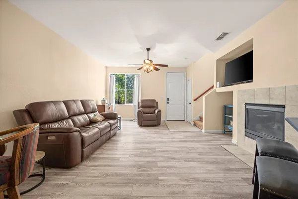 a living room with furniture a chandelier and kitchen view