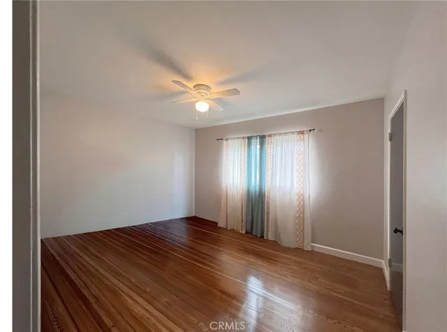 a view of a room with wooden floor and fan