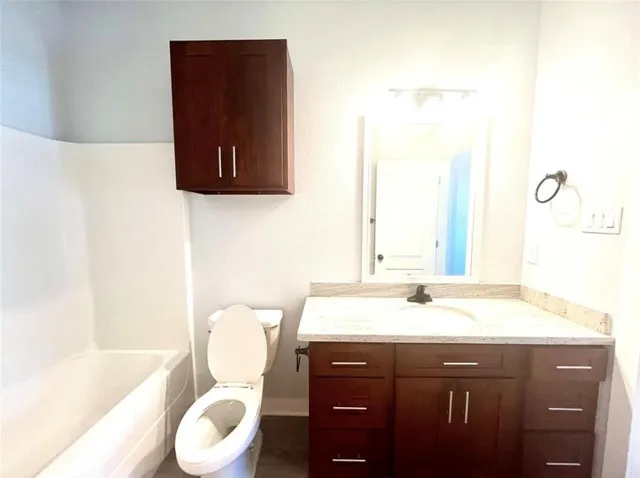 a bathroom with a sink vanity mirror and toilet