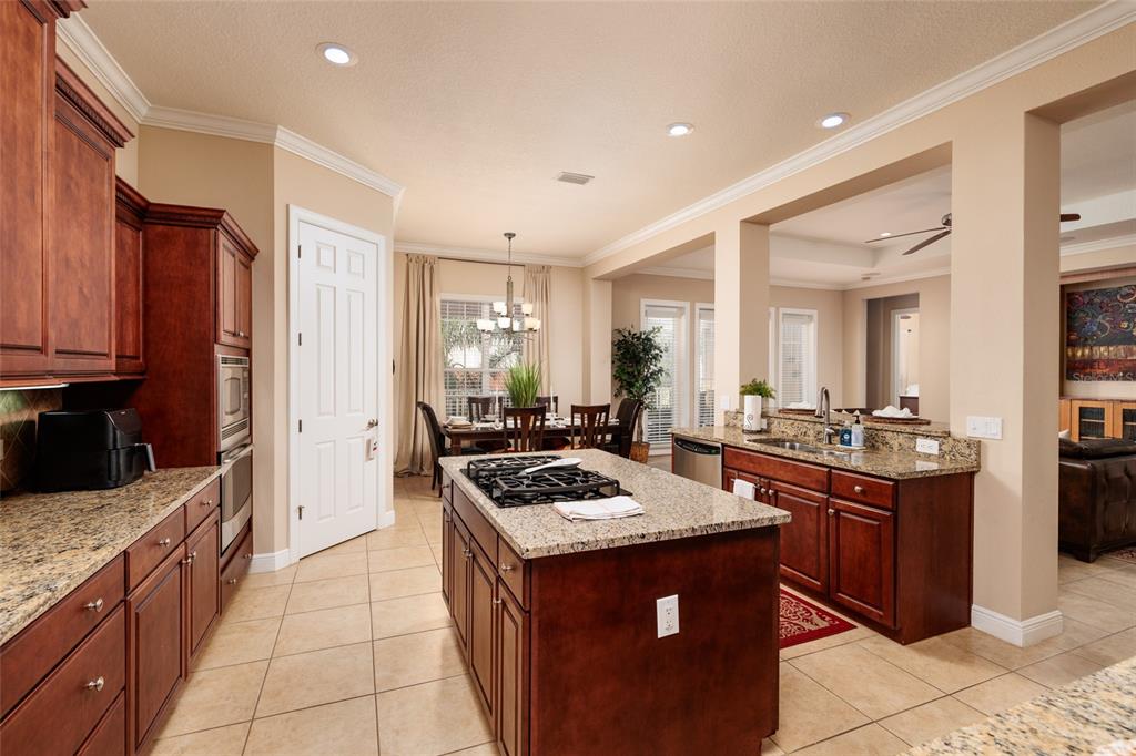 102 Wimbledon Court Redington Shores, FL 33708 - Photo 11 of 66 a kitchen with stainless steel appliances granite countertop a stove a sink dishwasher and a refrigerator with wooden cabinets