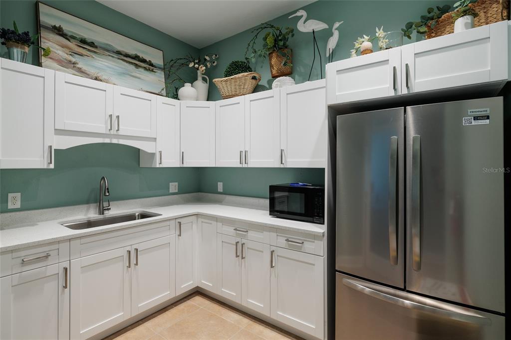 102 Wimbledon Court Redington Shores, FL 33708 - Photo 49 of 66 a kitchen with a sink and refrigerator