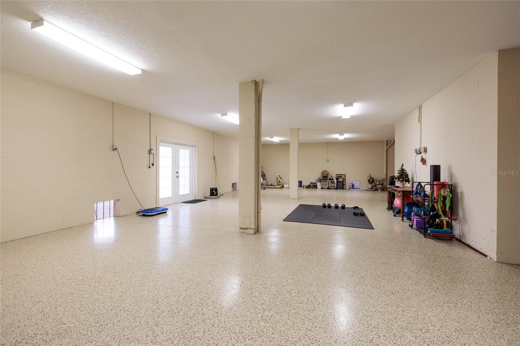 102 Wimbledon Court Redington Shores, FL 33708 - Photo 56 of 66 a view of a room with gym equipment and a chandelier
