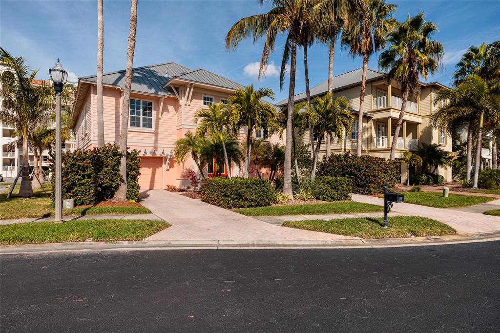 102 Wimbledon Court Redington Shores, FL 33708 - Photo 59 of 66 a front view of a house with a yard and garage