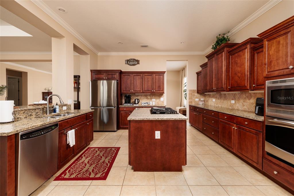 102 Wimbledon Court Redington Shores, FL 33708 - Photo 9 of 66 a large kitchen with stainless steel appliances granite countertop a stove top oven a sink dishwasher and a refrigerator