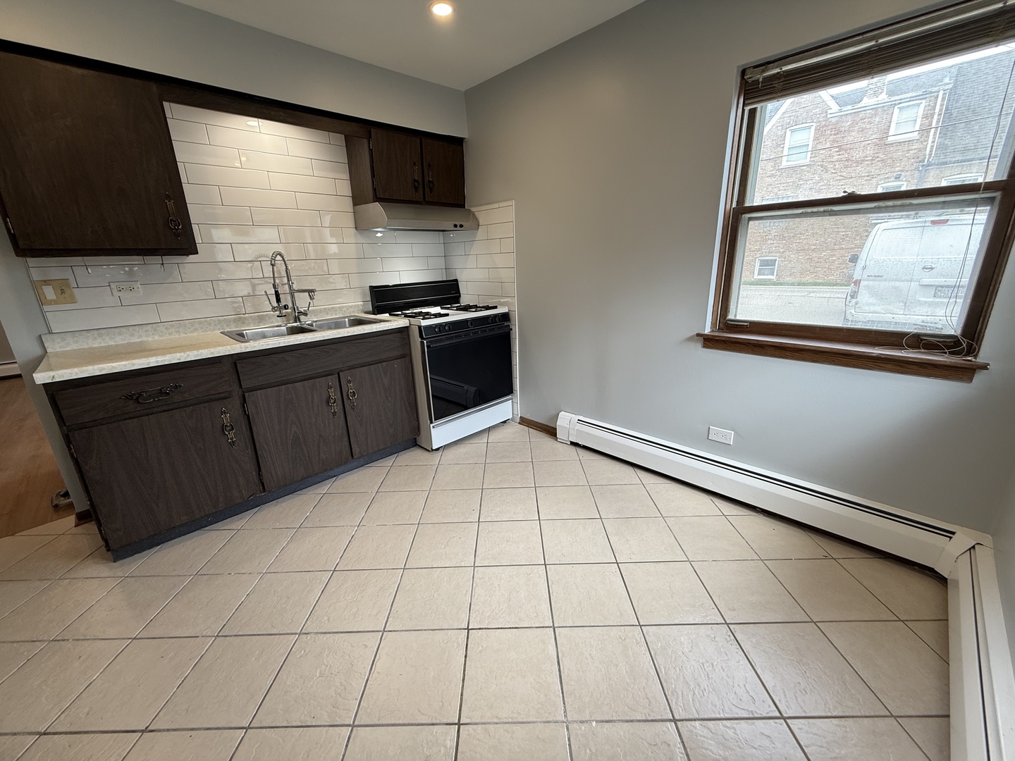 6543 16th Street, Unit 1N Berwyn, IL 60402 - Photo 8 of 11 a kitchen with stainless steel appliances a sink a stove a refrigerator a window and cabinets
