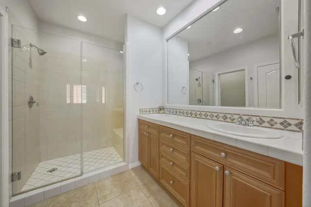 a bathroom with a shower sink and mirror