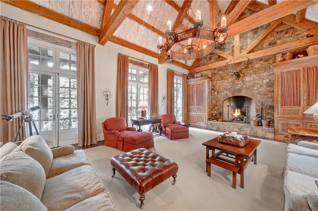 a living room with furniture a fireplace and a chandelier