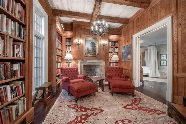 a living room with furniture a fireplace and a large window