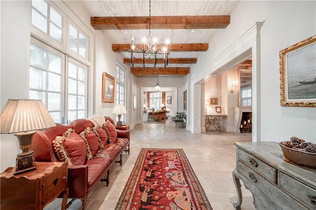 a living room with furniture a chandelier and a large window