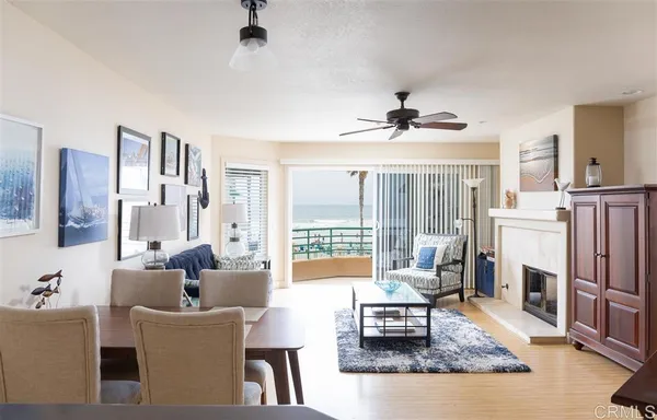 a living room with furniture a fireplace and a chandelier