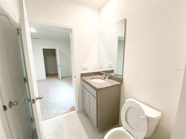 a bathroom with a granite countertop sink and a mirror
