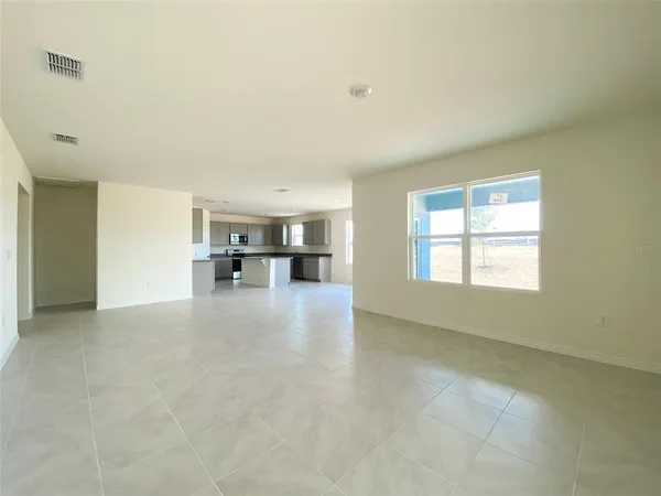 an empty room with a kitchen and windows