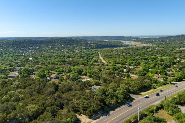 an aerial view of residential houses with outdoor space and trees