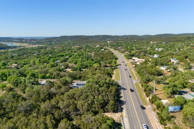 an aerial view of residential houses with outdoor space and trees