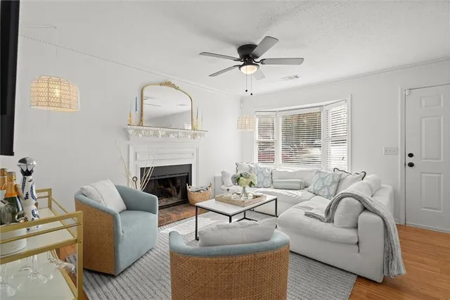 a living room with furniture a fireplace and a large window