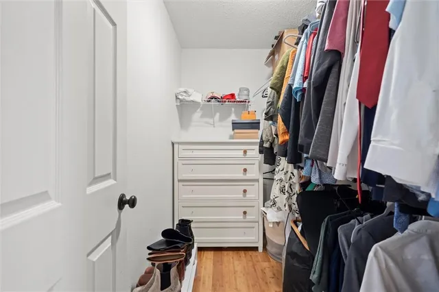 a view of walk in closet with clothes and shoes