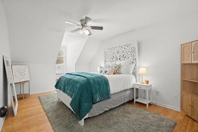 a bedroom with a bed rug and wooden floor
