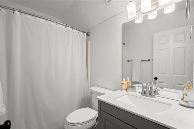 a bathroom with a sink vanity mirror and toilet