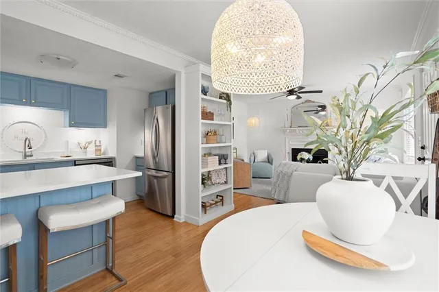 a living room with stainless steel appliances furniture a chandelier and a view of kitchen