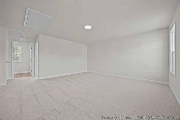 an empty room with wooden floor fireplace and fan